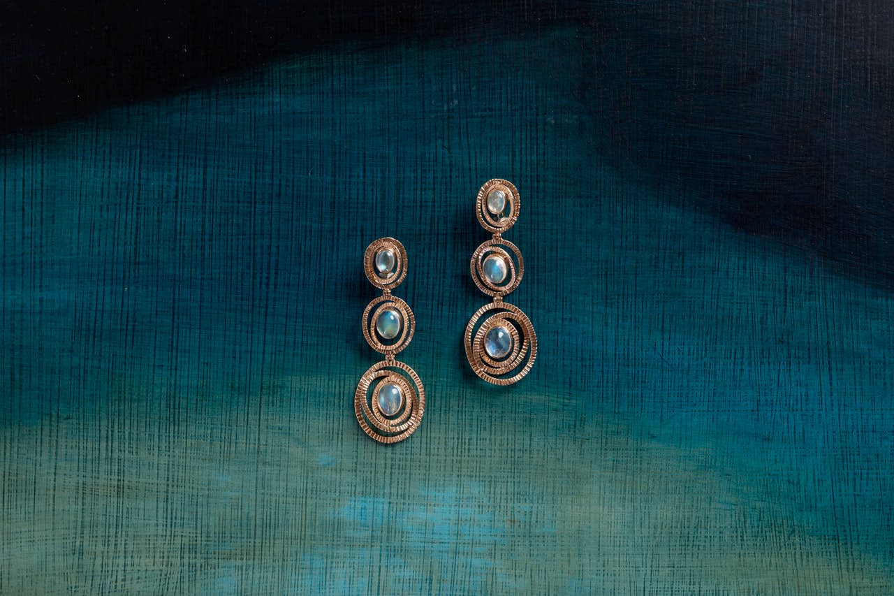 Maud Earrings on a blue background